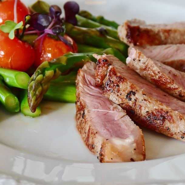 Der Bildschirm eines Laptops zeigt das Bild von Fleisch und Gemüse