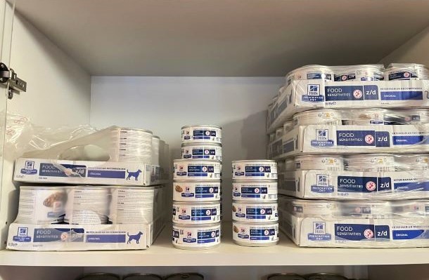 Das Bild zeigt ein Regal mit Futterdosen