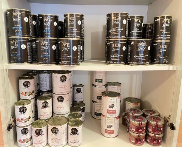 Das Bild zeigt ein Regal mit Futterdosen