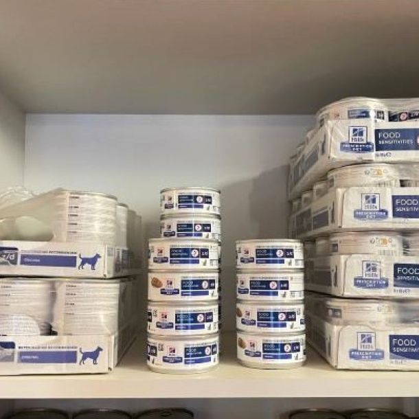 Das Bild zeigt ein Regal mit Futterdosen